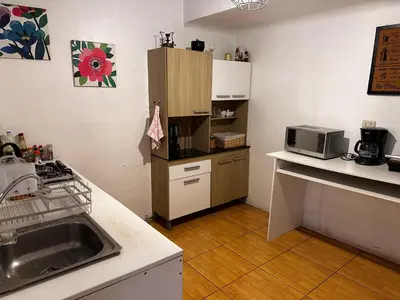 a small kitchen with a sink and a microwave at yuraqtampu- Pardo in Cusco