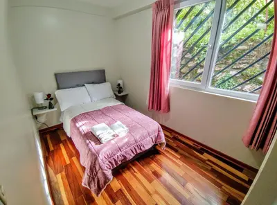 a bedroom with a bed and a large window at Zisary's House Apartment in Cusco