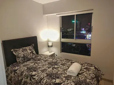 a bedroom with a bed and a window with a city at Met Moderno Departamento in Lima