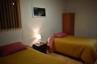 a hotel room with two beds and a lamp at saga andina in Cusco