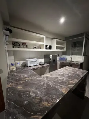 a kitchen with a marble counter top and a refrigerator at Dpto a 3 min Plaza Huánuco y 1 cuadra Open Plaza in Huánuco