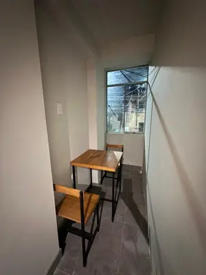 a table and chairs in a room with a window at Dpto a 3 min Plaza Huánuco y 1 cuadra Open Plaza in Huánuco