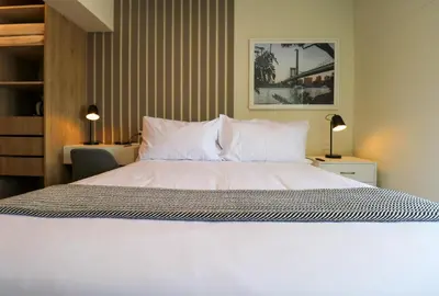 a bedroom with a large bed with white sheets and pillows at Pod by Wynwood House in Lima
