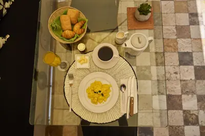 a table with a plate of food and a cup of coffee at Pucllana BBBoutique in Lima