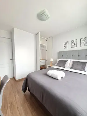 a white bedroom with a large bed with a white headboard at Miraflores - Dormitorio en Departamento compartido Baño Exclusivo Externo in Lima