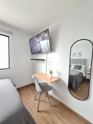a bedroom with a mirror and a table and a bed at Miraflores - Dormitorio en Departamento compartido Baño Exclusivo Externo in Lima