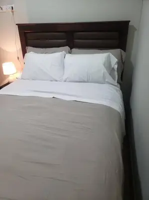 a bed with white sheets and pillows in a bedroom at Central, petfriendly family apartment in Lima