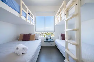 two beds in a room with a window at Sotavento Oceanfront Condos by Vibrant in Paracas