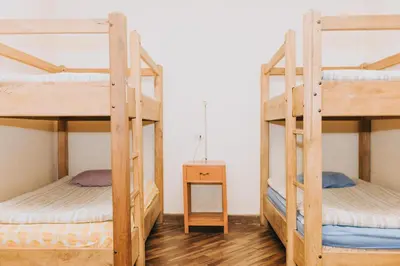 two bunk beds in a room with a table at Royal Frankenstein Hostel in Cusco