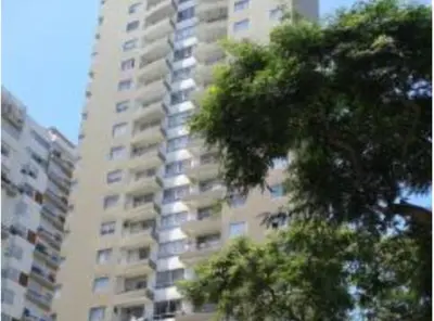 a tall building with a tree in front of it at Comfortapartment in Lima
