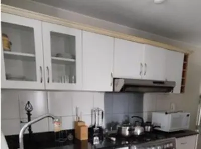 a kitchen with white cabinets and a counter top at Comfortapartment in Lima