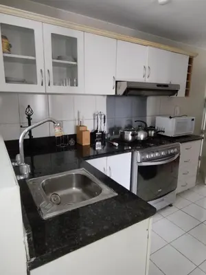 a kitchen with a sink and a stove at Comfortapartment in Lima