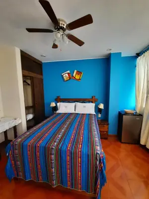 a bedroom with a bed with a blue wall at BRISAS DE LA BAHIA HOTEL in Paracas