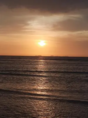a sunset over the ocean with the sun setting at BRISAS DE LA BAHIA HOTEL in Paracas