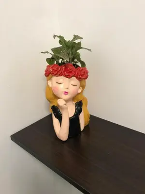 a doll with a flower on her head sitting on a shelf at Albano habitación acústica cocina y baño in Chosica