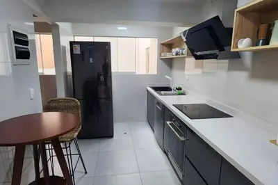 a kitchen with a table and a black refrigerator at Amazing 3BR in Miraflores in Lima
