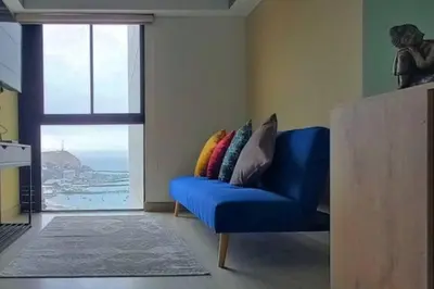 a blue couch in a living room with a window at Apartamento con increíble vista al mar in Lima