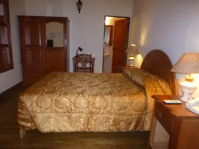 a bedroom with a bed and a table with a lamp at Hotel Midori in Cusco