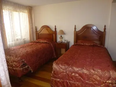 a bedroom with two beds and a window at Hotel Midori in Cusco