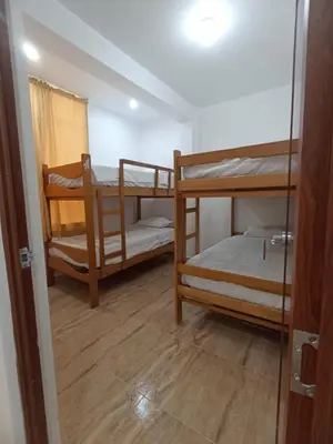 a room with two bunk beds and a door at Mini Hostal Cardos in Pisco