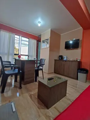 a living room with a table and chairs at Mini Hostal Cardos in Pisco