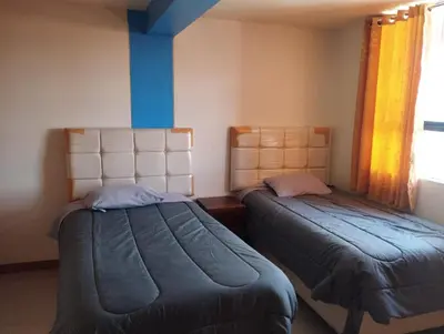 a bedroom with two beds and a window at hotel plaza chinchero in Cusco