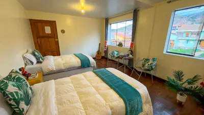 a bedroom with two beds and a window at Apart Hotel de Alegria in Cusco