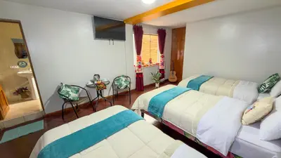 a bedroom with two beds and a window at Apart Hotel de Alegria in Cusco