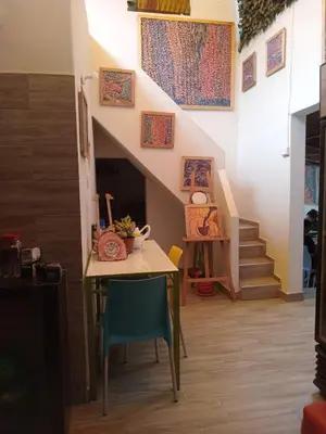 a table and chairs in a room with a staircase at Colores Hospedaje Miraflores in Lima