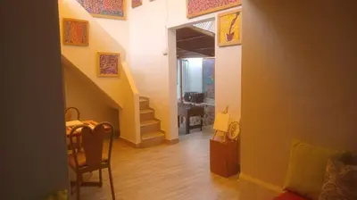 a hallway with a staircase and a table and chair at Colores Hospedaje Miraflores in Lima