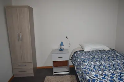 a bedroom with a bed and a dresser and a bed and a cabinet at Saga Andina II in Cusco