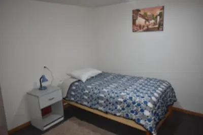 a bedroom with a bed and a nightstand with a picture on the wall at Saga Andina II in Cusco