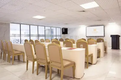 a conference room with tables and chairs and a screen at Luxury Inkari Hotel in Lima