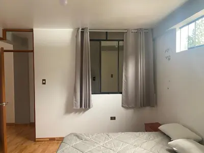 a bedroom with a bed and a mirror at Casa Hospedaje El Trebol in Oxapampa