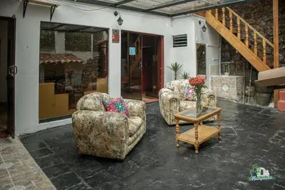 two chairs and a table with a vase of flowers at BEAUTIFUL, SPACIOUS & COZY HOUSE LOCATED IN THE HEART OF CUSCO in Cusco