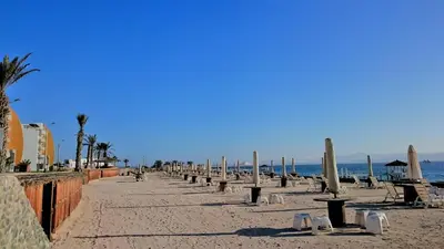 a beach with chairs and umbrellas and the ocean at Nuevo Paracas Apartment in Paracas