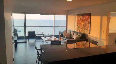 a living room with a view of the ocean at Nuevo Paracas Apartment in Paracas