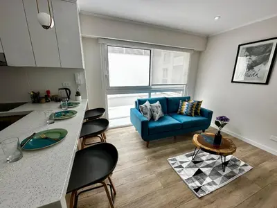 a kitchen and a living room with a blue couch at Cozy Apartment in Barranco! in Lima