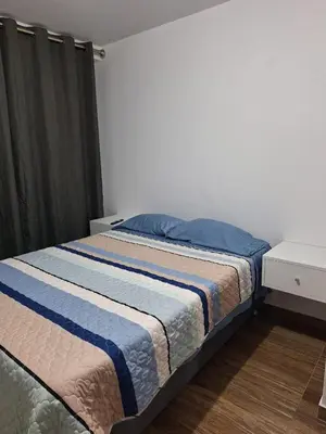 a bedroom with a bed with a blue and white blanket at Dormitorio matrimonial 02 in Lima