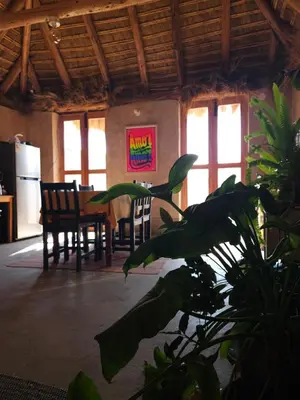 a room with a table and chairs and a plant at Pampachayoq - Mountain retreat in Urubamba