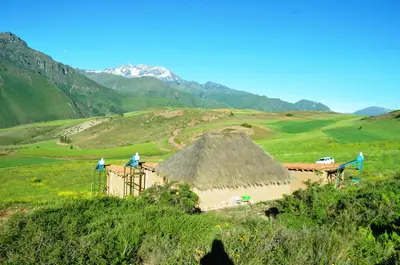 two people standing on top of a building in a field at Pampachayoq - Mountain retreat in Urubamba