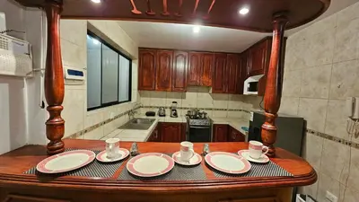 a kitchen with a wooden table with plates and cups at Casa Independiente cerca al centro historico en Primer Piso - Los Profesionales in Cusco
