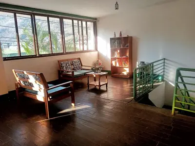 a living room with chairs and a table and windows at Casa Verde in Quillabamba