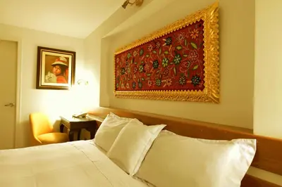 a bedroom with a bed and a painting on the wall at Tandapata Boutique Hotel in Cusco