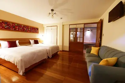 a hotel room with two beds and a couch at Tandapata Boutique Hotel in Cusco