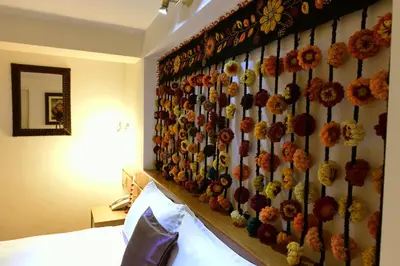 a bedroom with a wall with flowers on it at Tandapata Boutique Hotel in Cusco