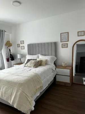 a bedroom with a large bed and a mirror at Departamento Calido y familiar in Lima