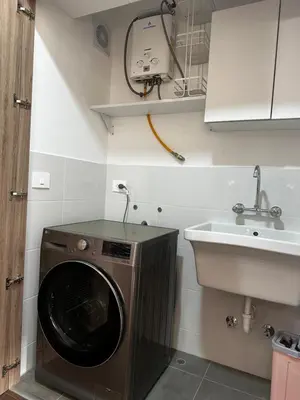 a kitchen with a washing machine and a sink at Departamento Calido y familiar in Lima