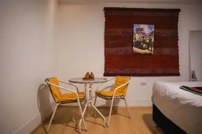 a room with a table and two chairs and a bed at RumiUma Boutique Hotel in Cusco
