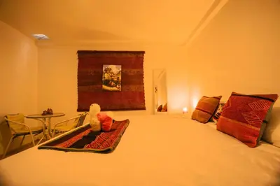a bedroom with a bed with a table and a window at RumiUma Boutique Hotel in Cusco
